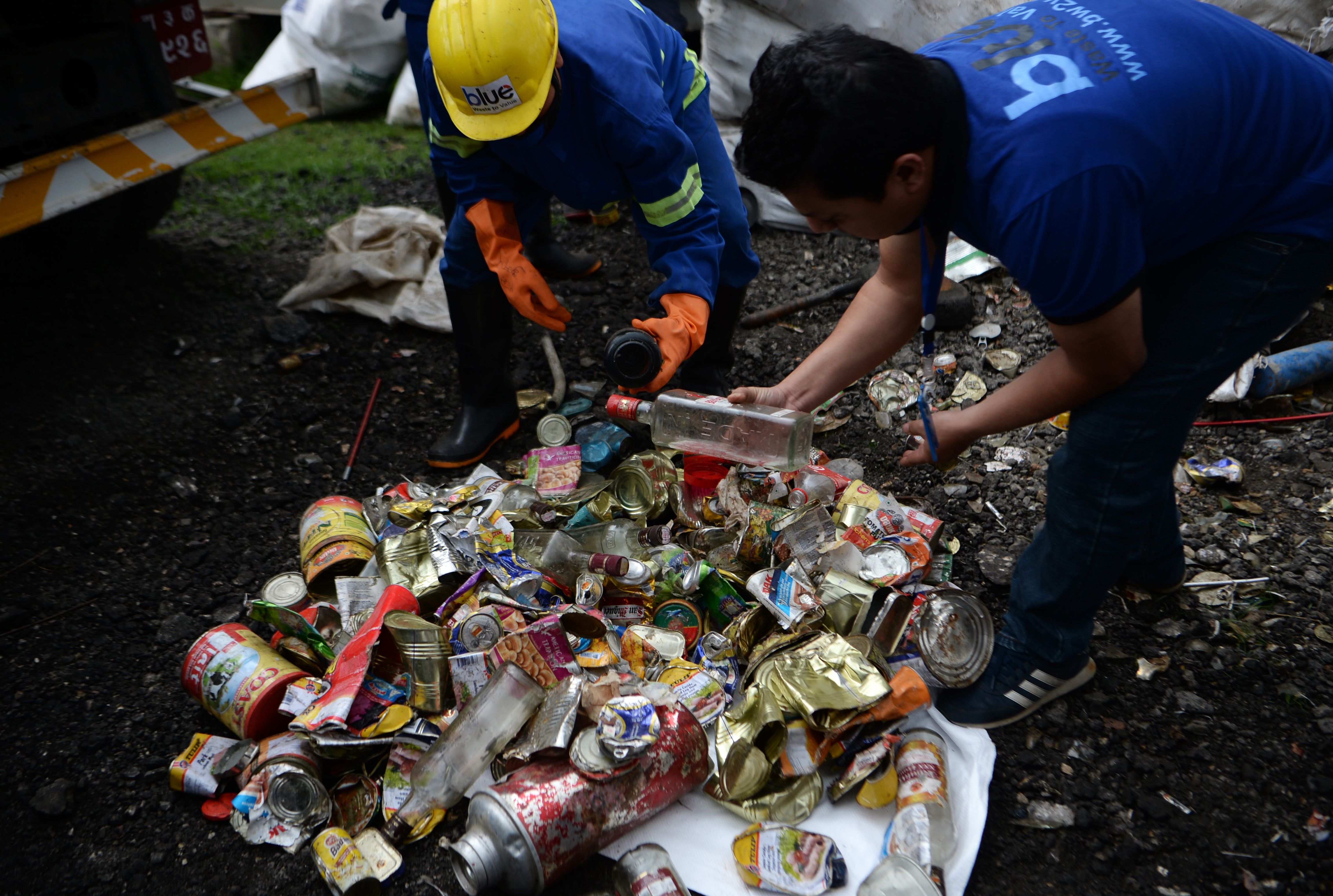 Nepali workers search for recyclable materials from a a pile of waste collected from Mount Everest, in Kathmandu in 2019