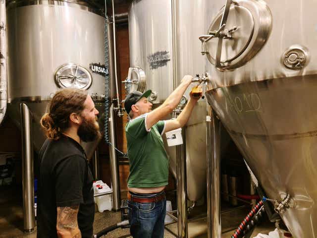 <p>Young Henrys brewery co-founders Oscar McMahon (L) and Richard Adamson pour beer from their fermentation tanks at the brewery in Sydney, Australia</p>