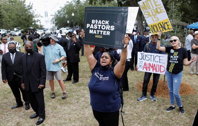 <p>People hold placards reading ‘Black Pastors Matter’ outside the courthouse on Thursday</p>