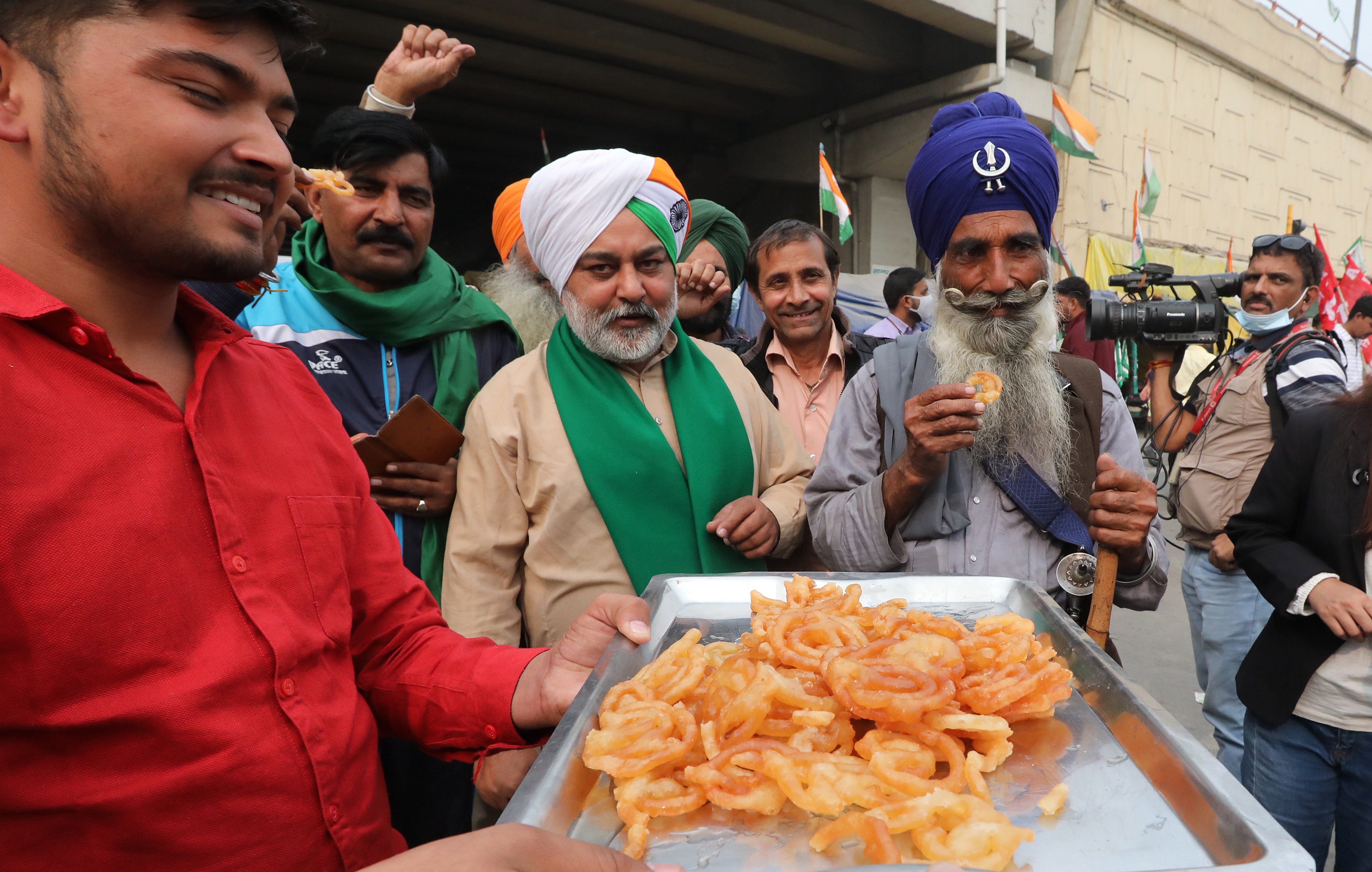 Indian farmers celebrate at the Delhi-Uttar Pradesh border after the announcement of the repeal of the farm laws