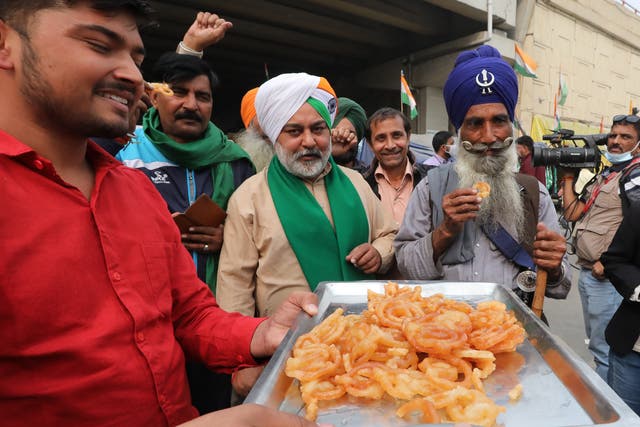 <p>Indian farmers celebrate at the Delhi-Uttar Pradesh border after the announcement of the repeal of the farm laws</p>