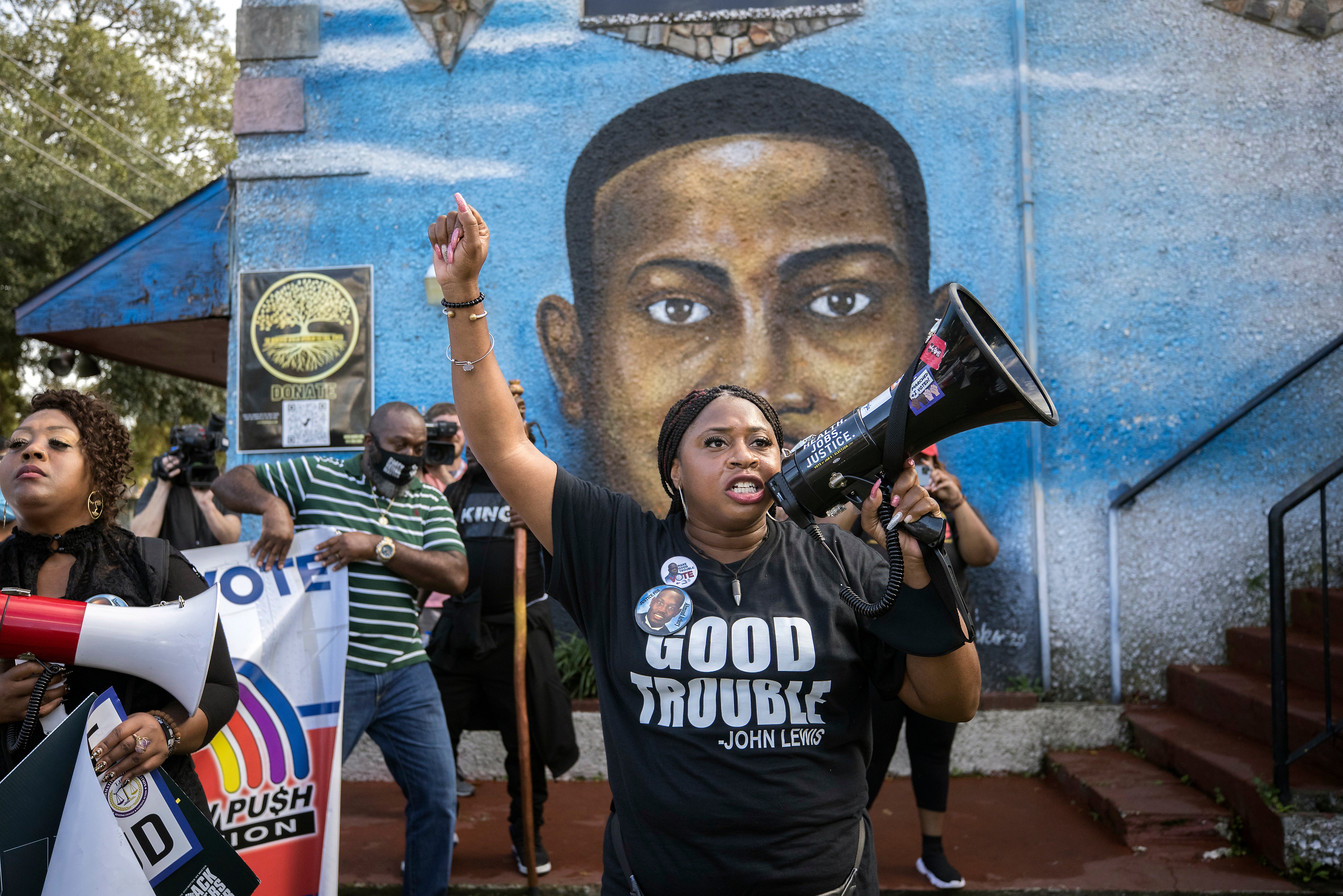 Supporters of Ahmaud Arbery’s family gather in front of a mural of him during a march in Brunswick, Georgia, on day 10 of the trial