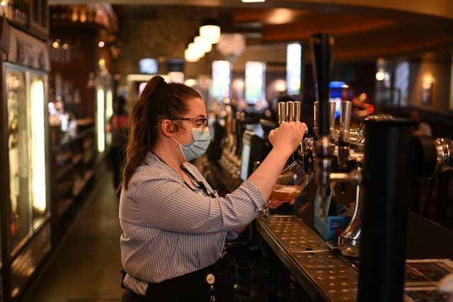 <p>A member of staff pulls a pint in a Wetherspoons pub</p>