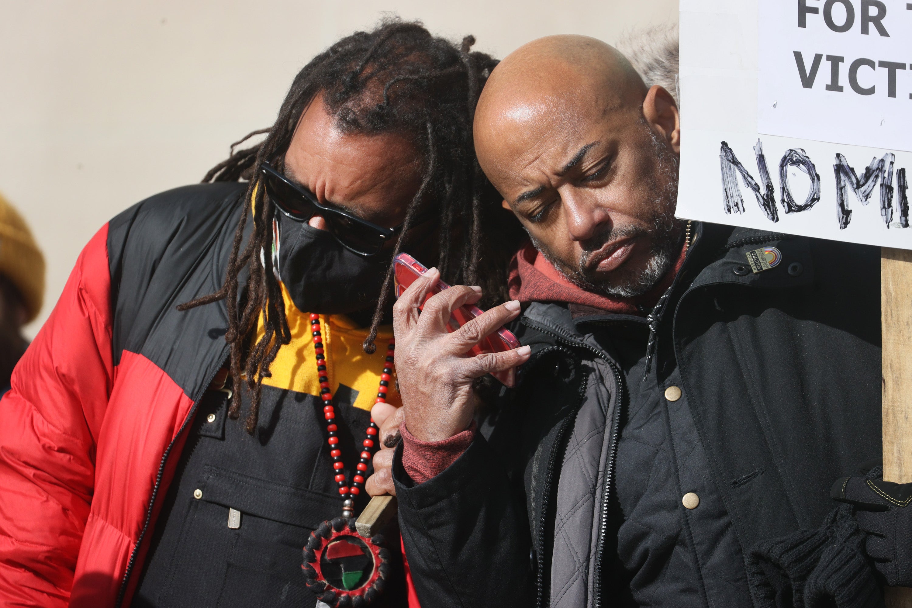 Justin Blake, left, the uncle of Jacob Blake, and Bishop Tavis Grant listen to the verdict in the Kyle Rittenhouse trial outside the Kenosha County Courthouse on 19 November