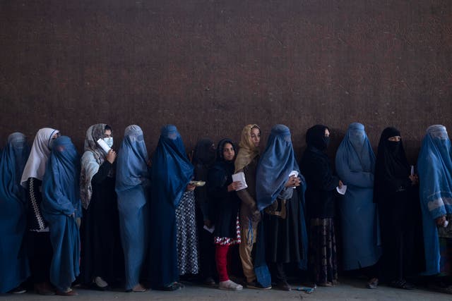 <p>Women line up to receive cash at a money distribution point organised by the World Food Program in Kabul </p>