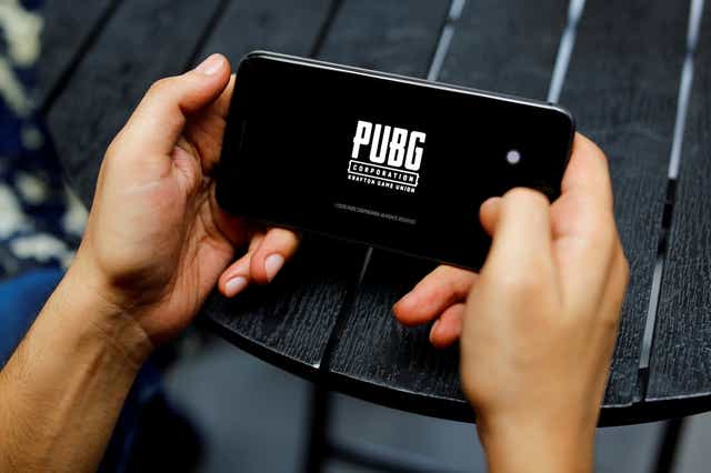<p>File Photo: A boy plays Tencent Holdings’ PUBG videogame on his mobile phone at a cafe in New Delhi, India</p>