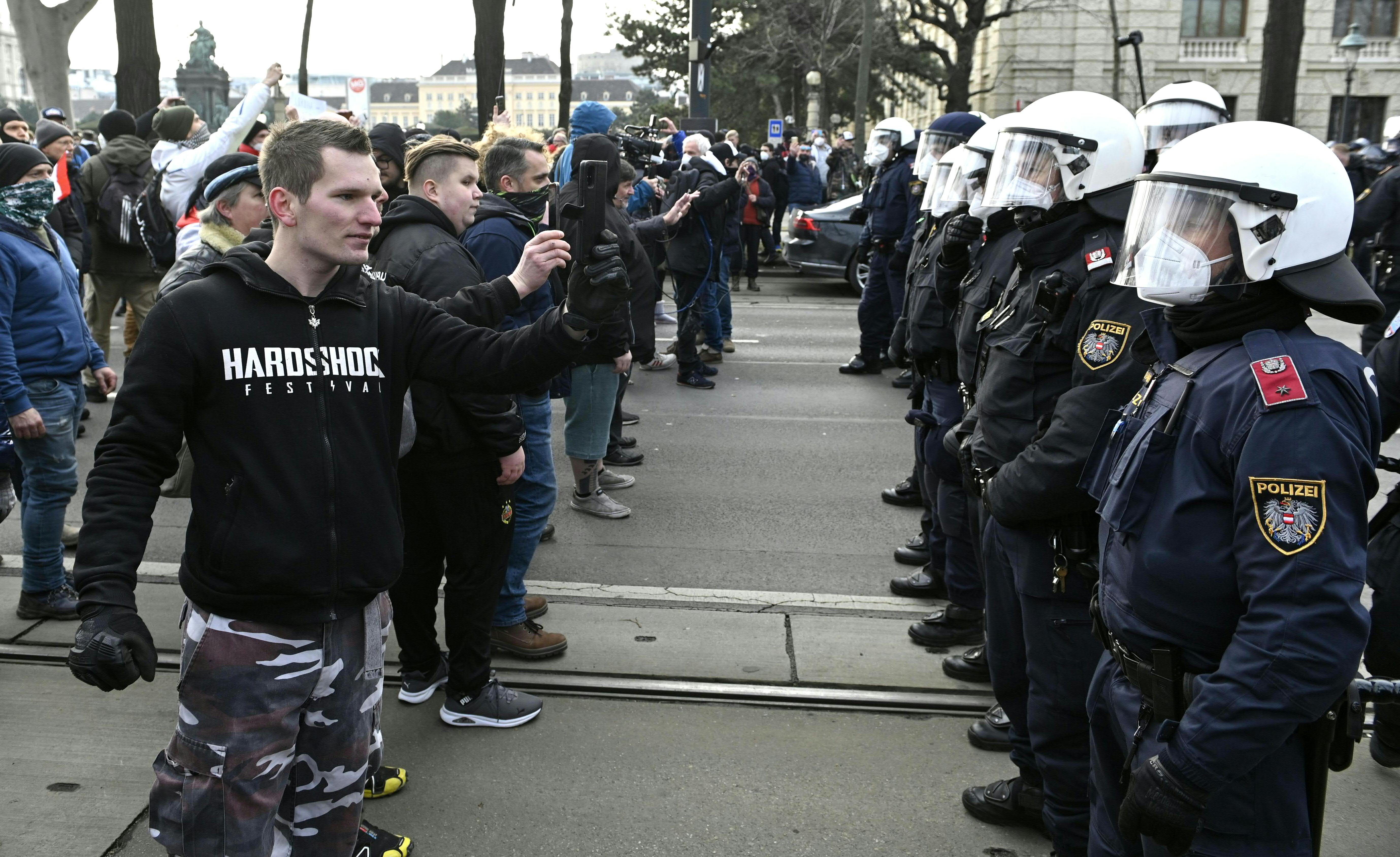 Austrian protesters take pictures of the police during a demonstration against Covid restrictions