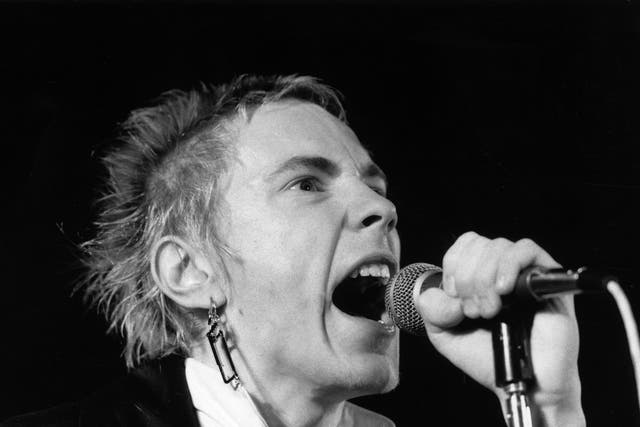 <p>Johnny Rotten performs on stage in December 1976</p>