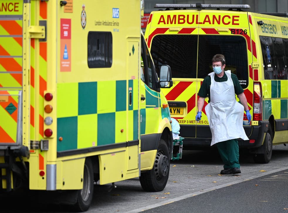 <p>A paramedic walks past ambulances outside the Royal London Hospital</p>