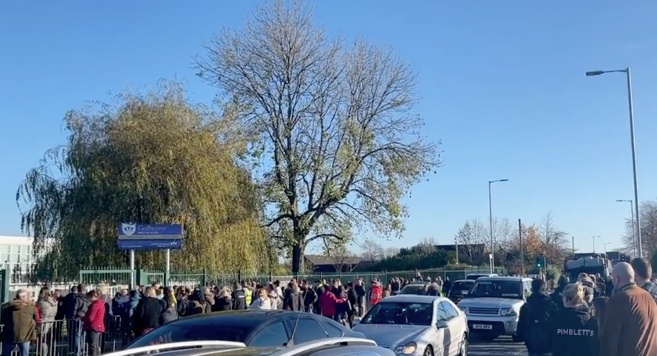 Parents wait for their children outside of Golborne High School in Wigam