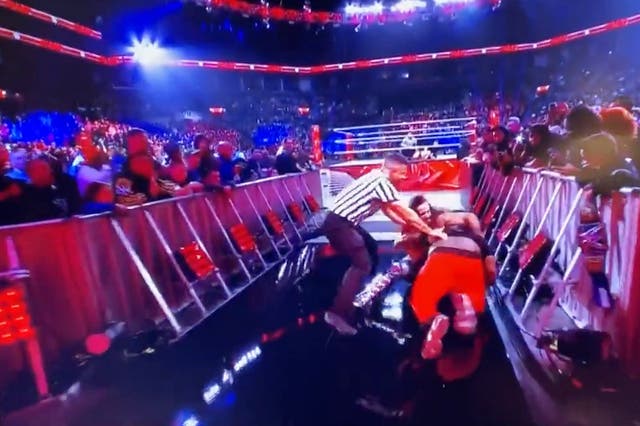 <p>A fan attacks wrestler Seth Rollins</p>