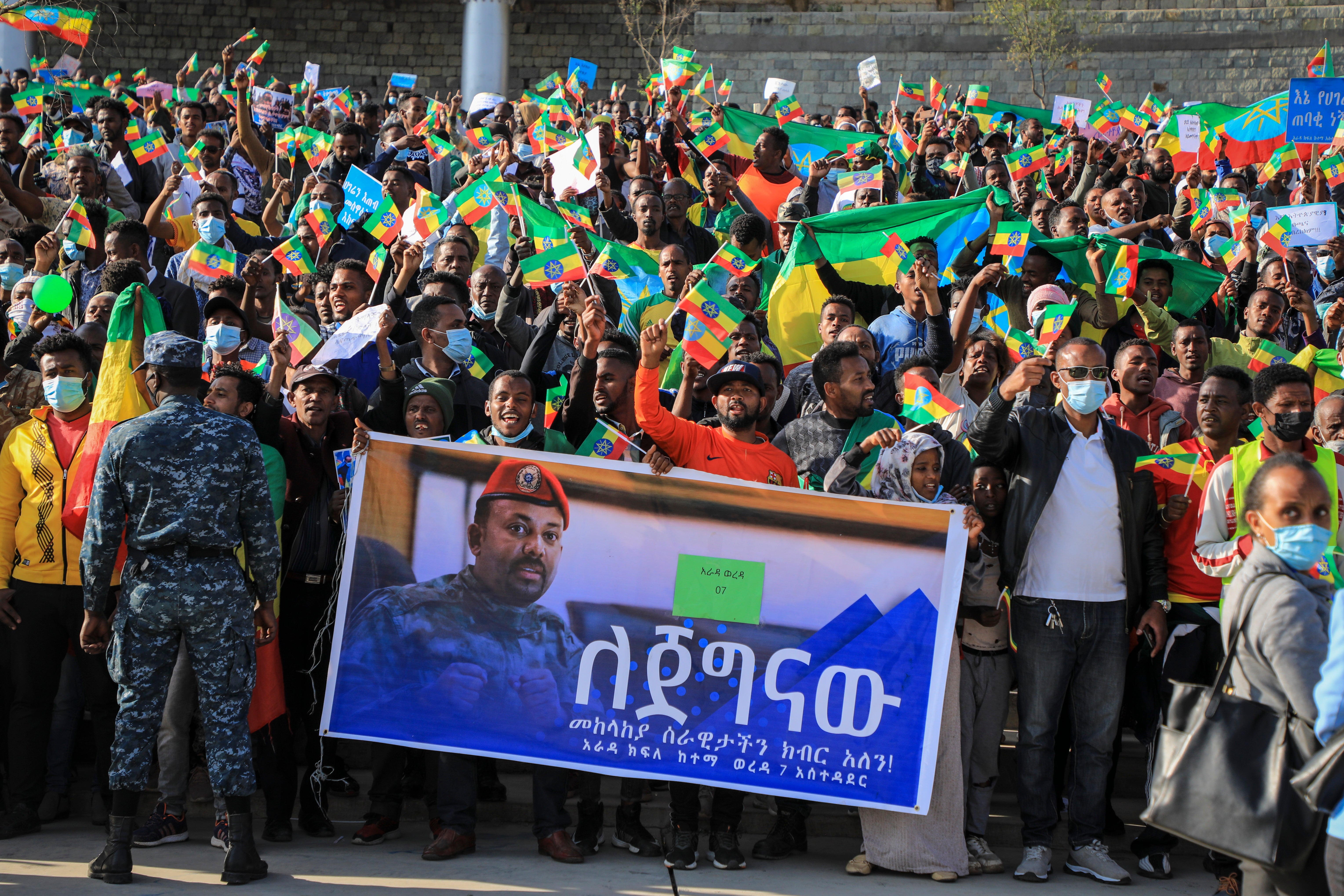 People gather behind a placard showing Prime Minister Abiy Ahmed