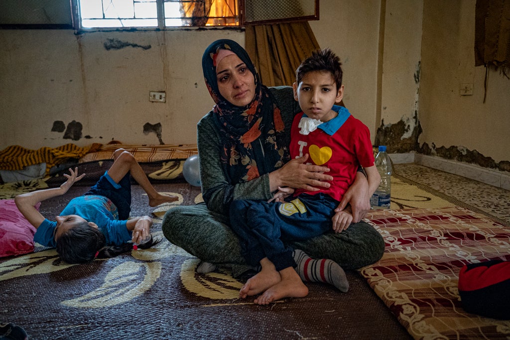 Hanan sits with her emaciated son Firas who has cerebral palsy