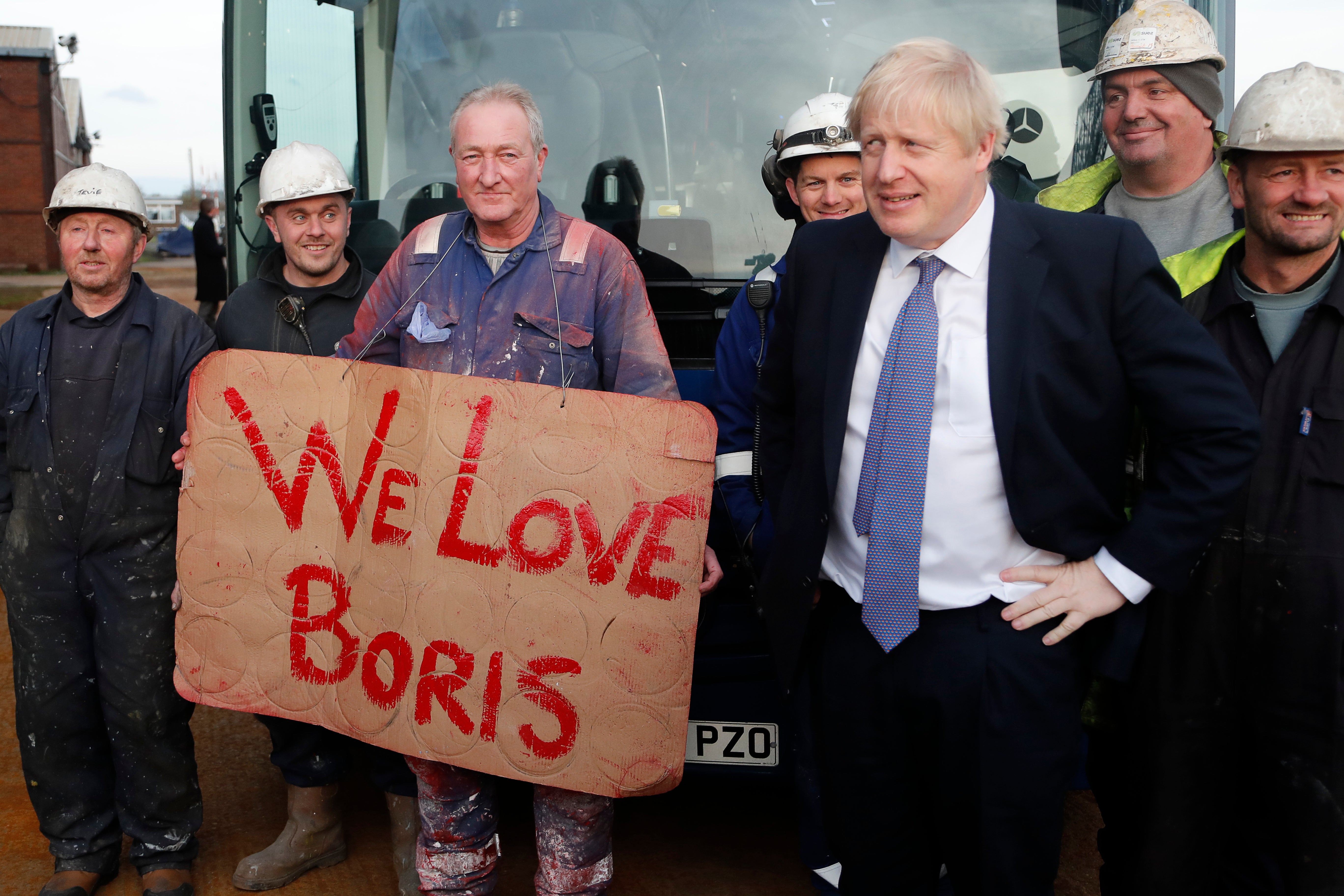 Johnson poses with workers during a visit to Wilton Engineering Services in Middlesbrough, England