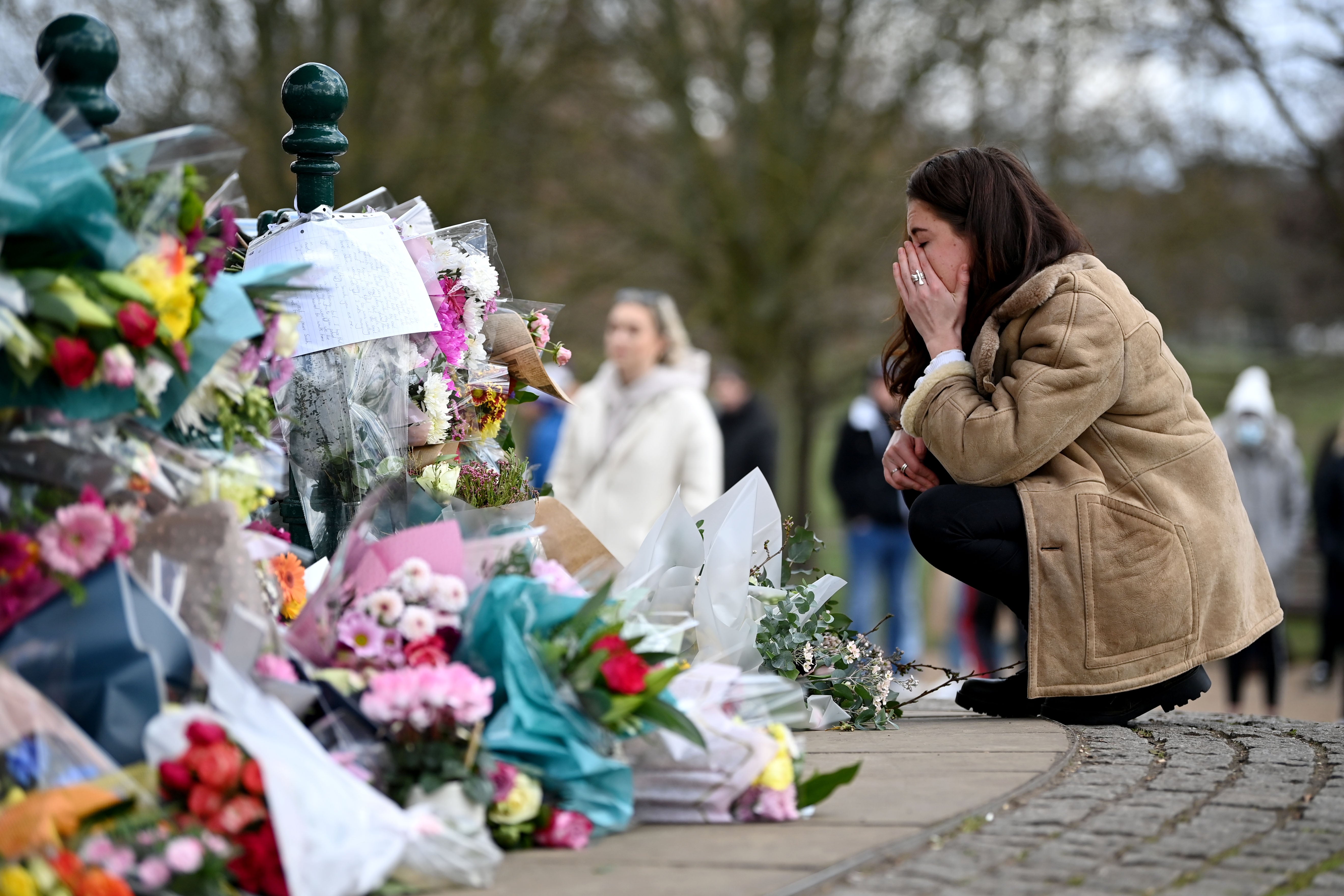 A woman lays flowers at the bandstand on Clapham Common in tribute to Sarah Everard