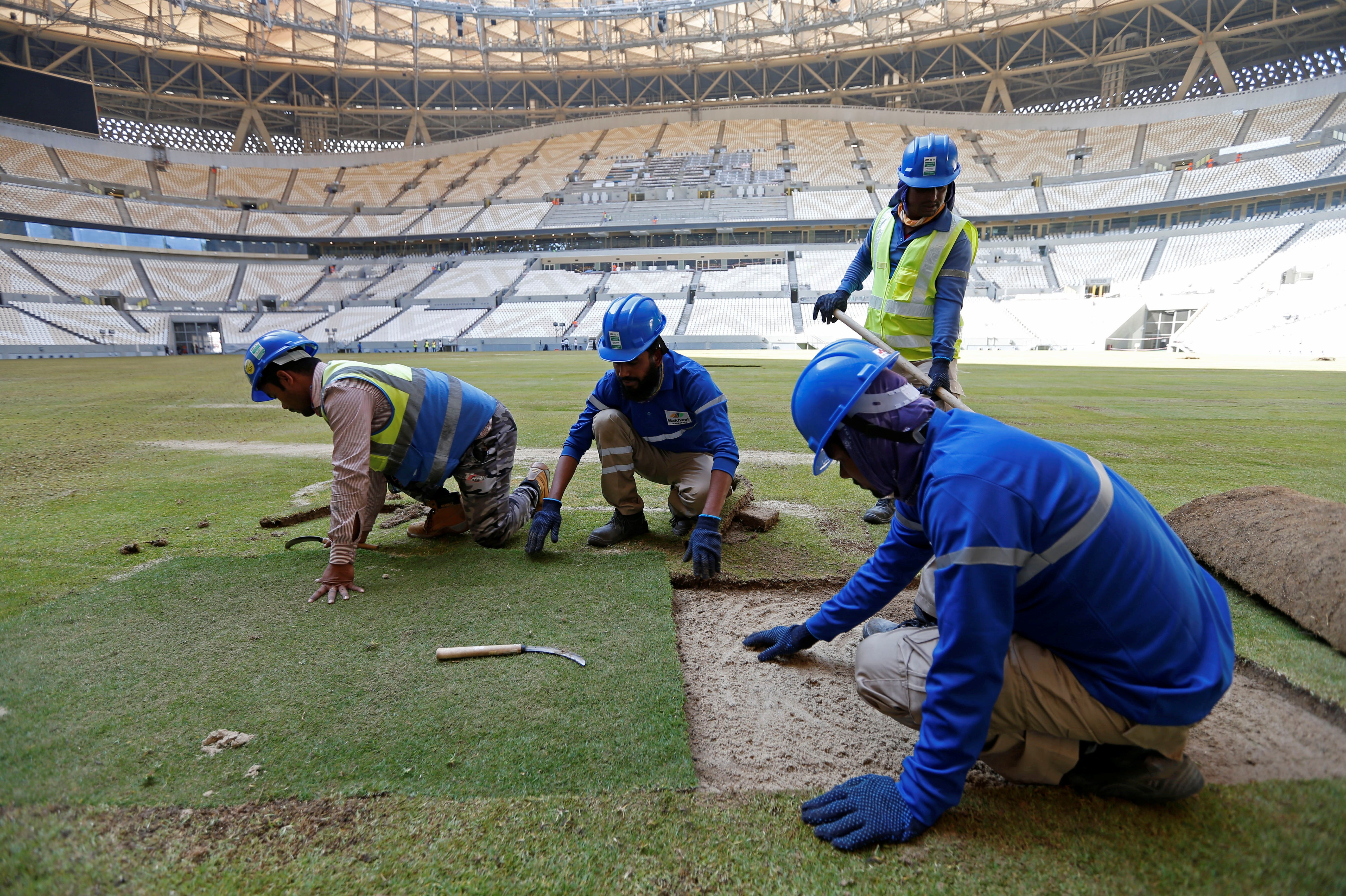 Workers lay turf inside the Lusail Stadium, the venue for the 2022 Qatar World Cup final