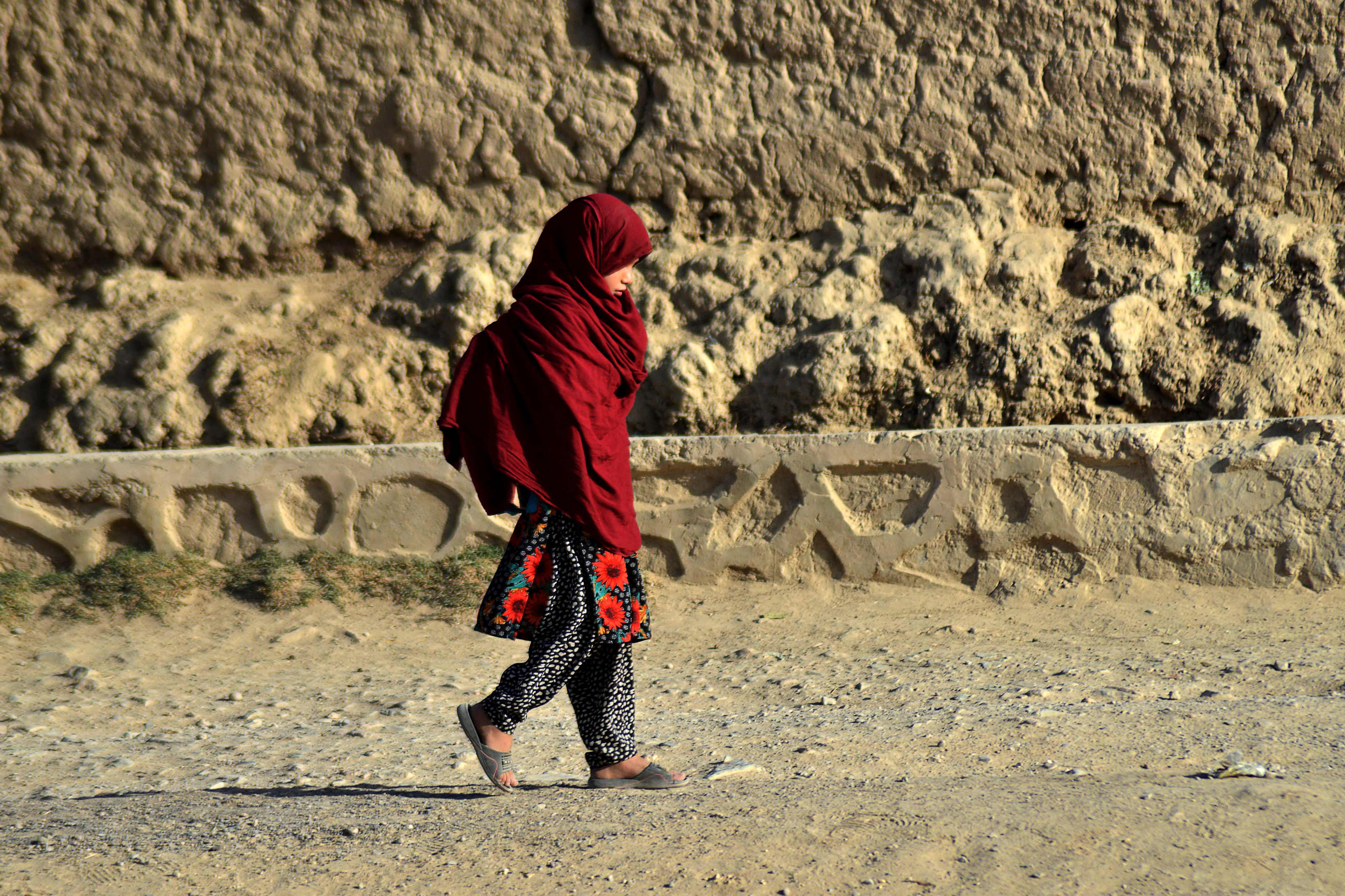 File: A child walks towards her school in Kandahar
