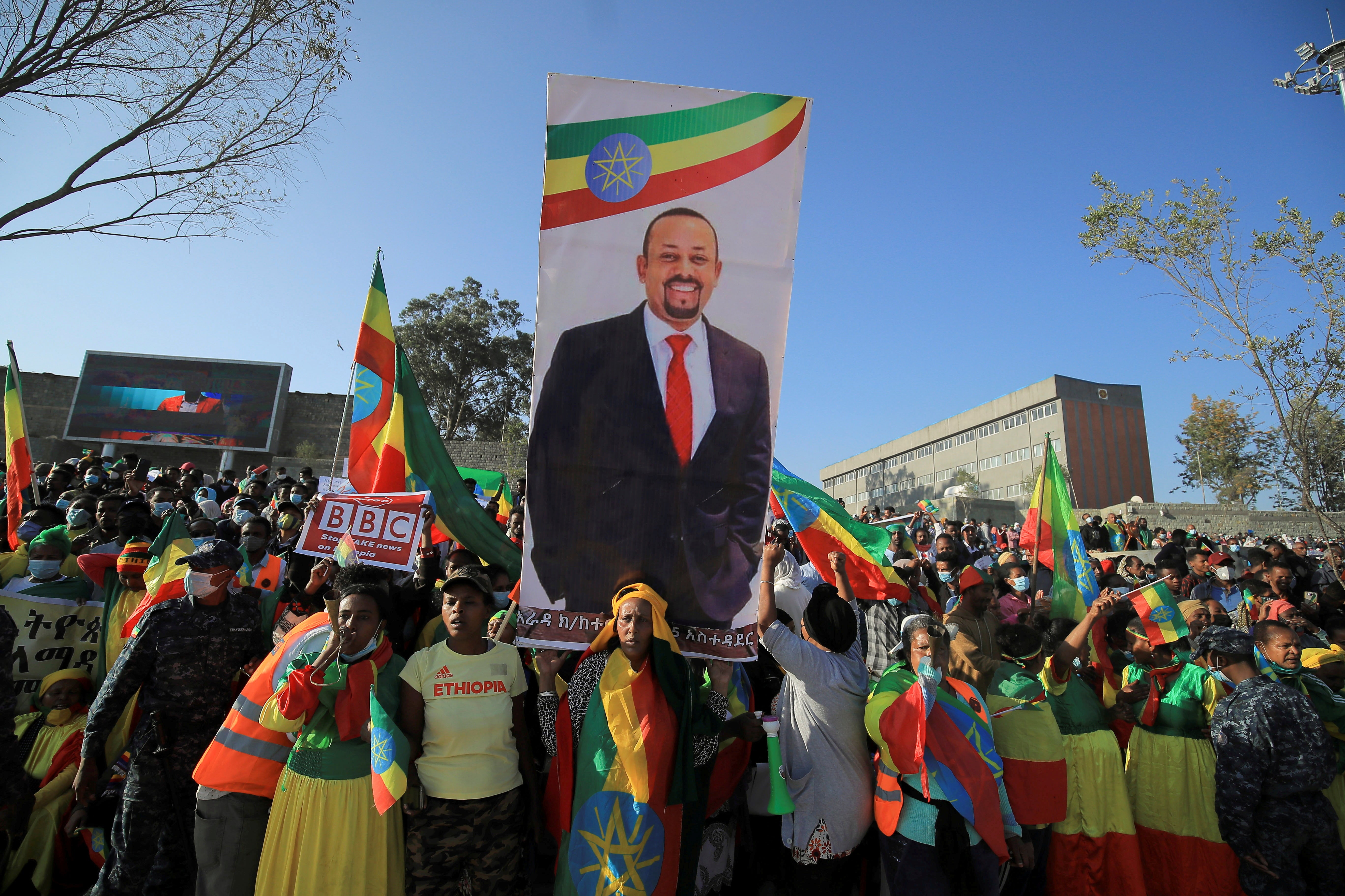 Civilians carry a placard with Prime Minister Abiy Ahmed’s portrait during a pro-government rally