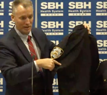 NYPD Commissioner Dermot Shea points to where a hole pierced an injured police officer’s uniform