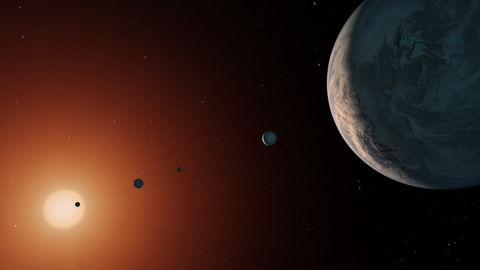 An illustration showing what the TRAPPIST-1 system might look like from a vantage point near planet TRAPPIST-1f (right).