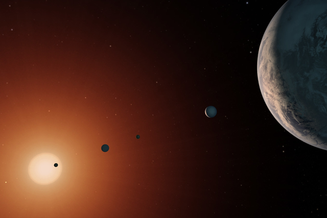 Una ilustración que muestra cómo se vería el sistema TRAPPIST-1 desde un punto de vista cerca del planeta TRAPPIST-1f (derecha).