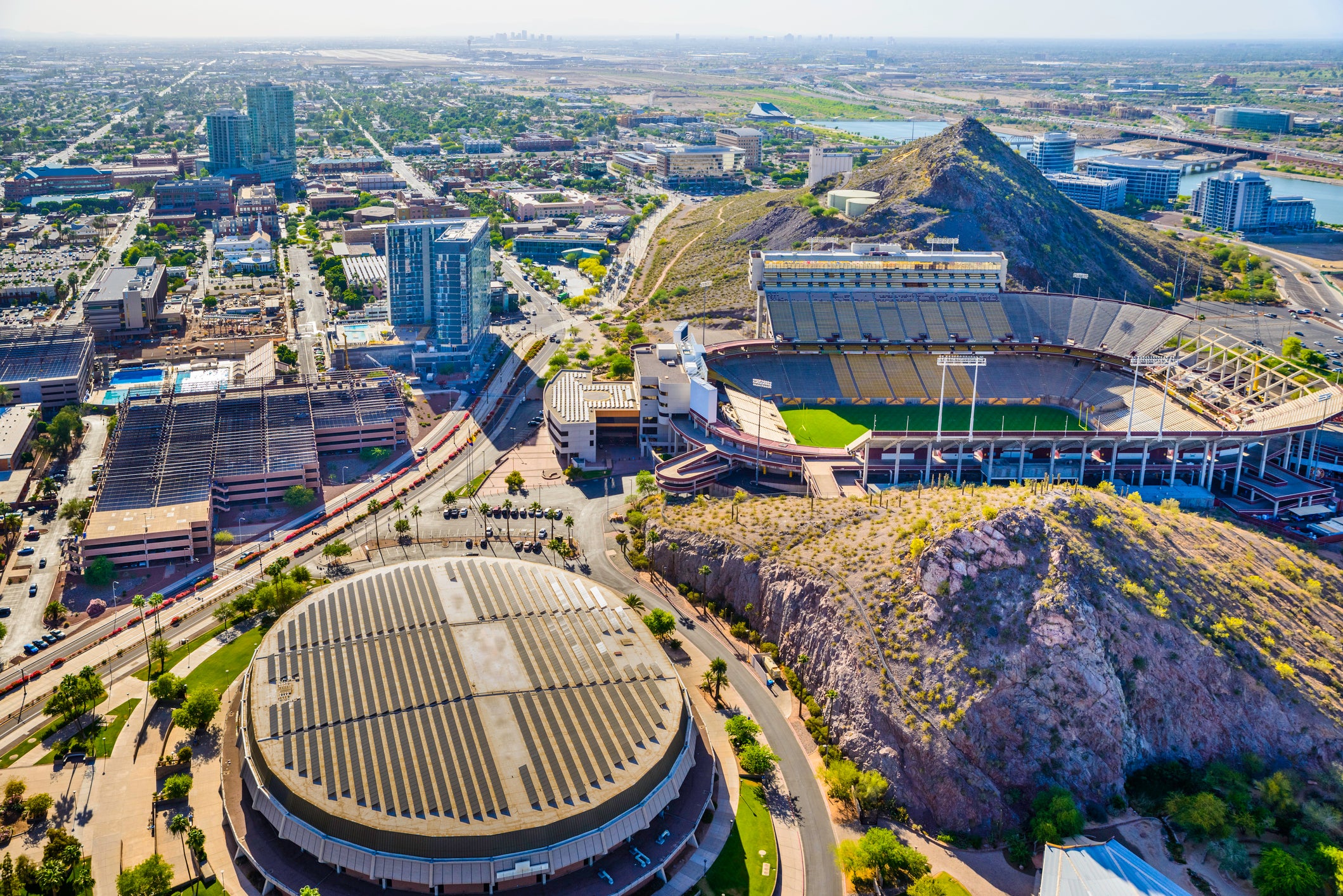 Skyline panoramic aerial helicopter view of Tempe, Arizona, showing ASU Arizona State University campus with Sun Devil Football Stadium (Frank Kush Field) on middle right.