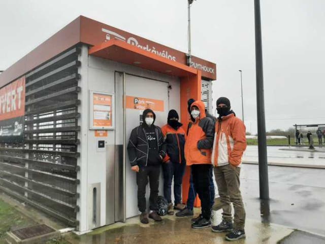 <p>A group of men from Iran shelter from rain in Dunkirk </p>