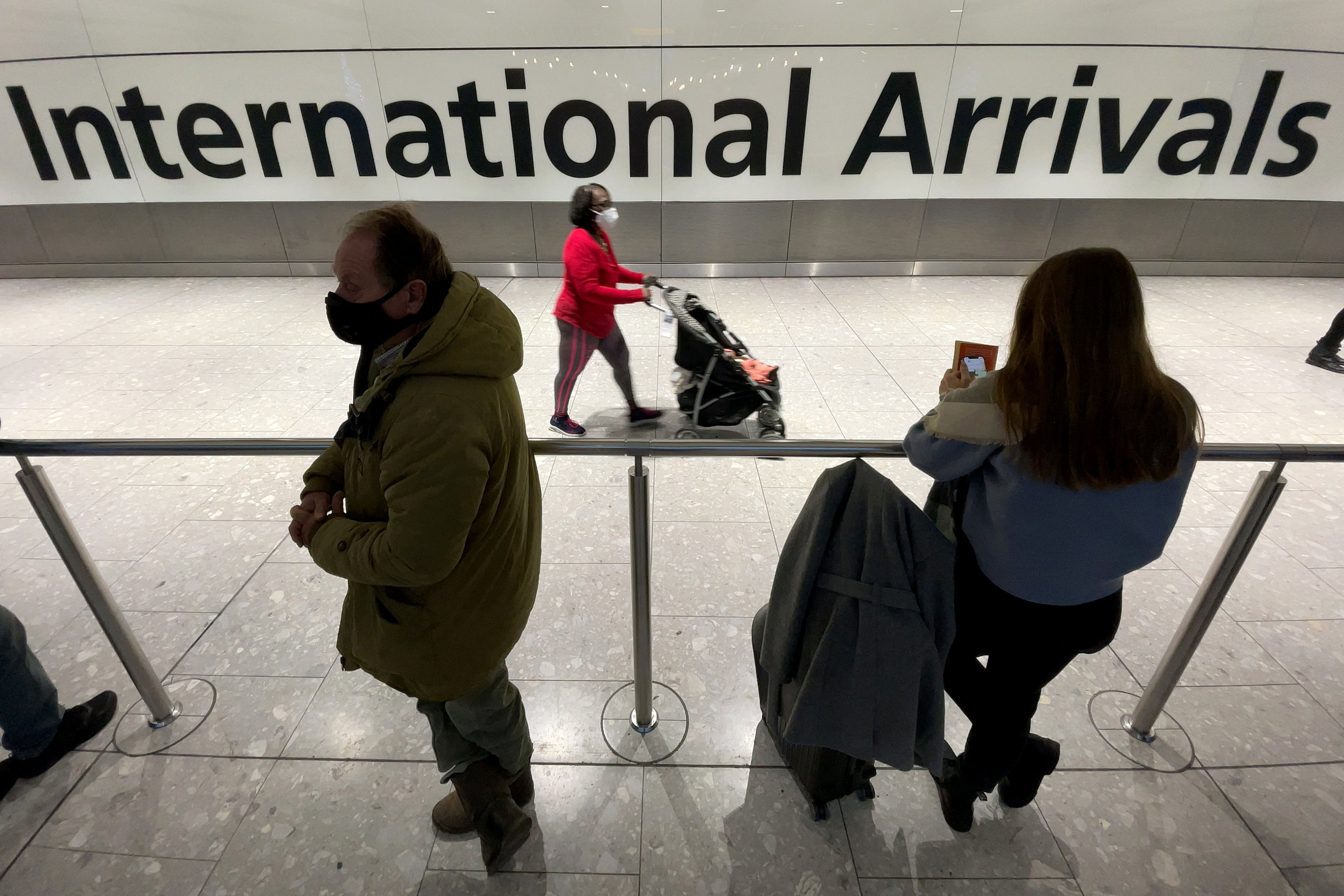 International passengers walk through the arrivals area at Terminal 5 at Heathrow Airport on 26 November where flights to six African countries have been suspended