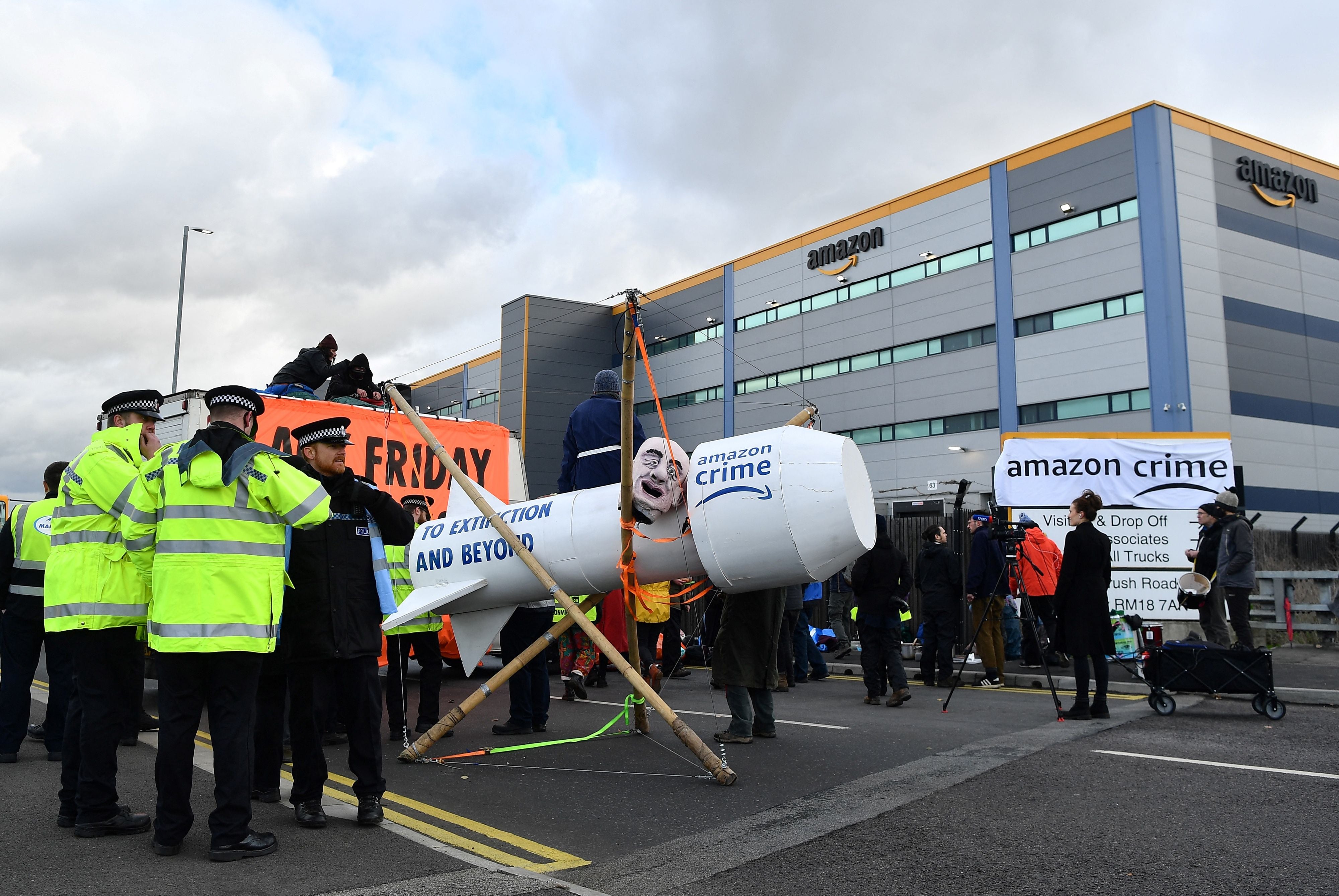 Police officers are pictured beside an Extinction Rebellion (XR) protest outside an Amazon warehouse in Tilbury, Essex, on 26 November, 2021.