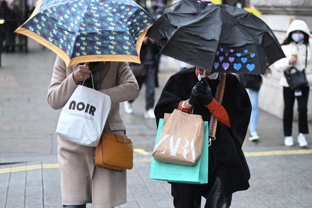 <p>Shoppers sheltered from the rain under umbrellas</p>