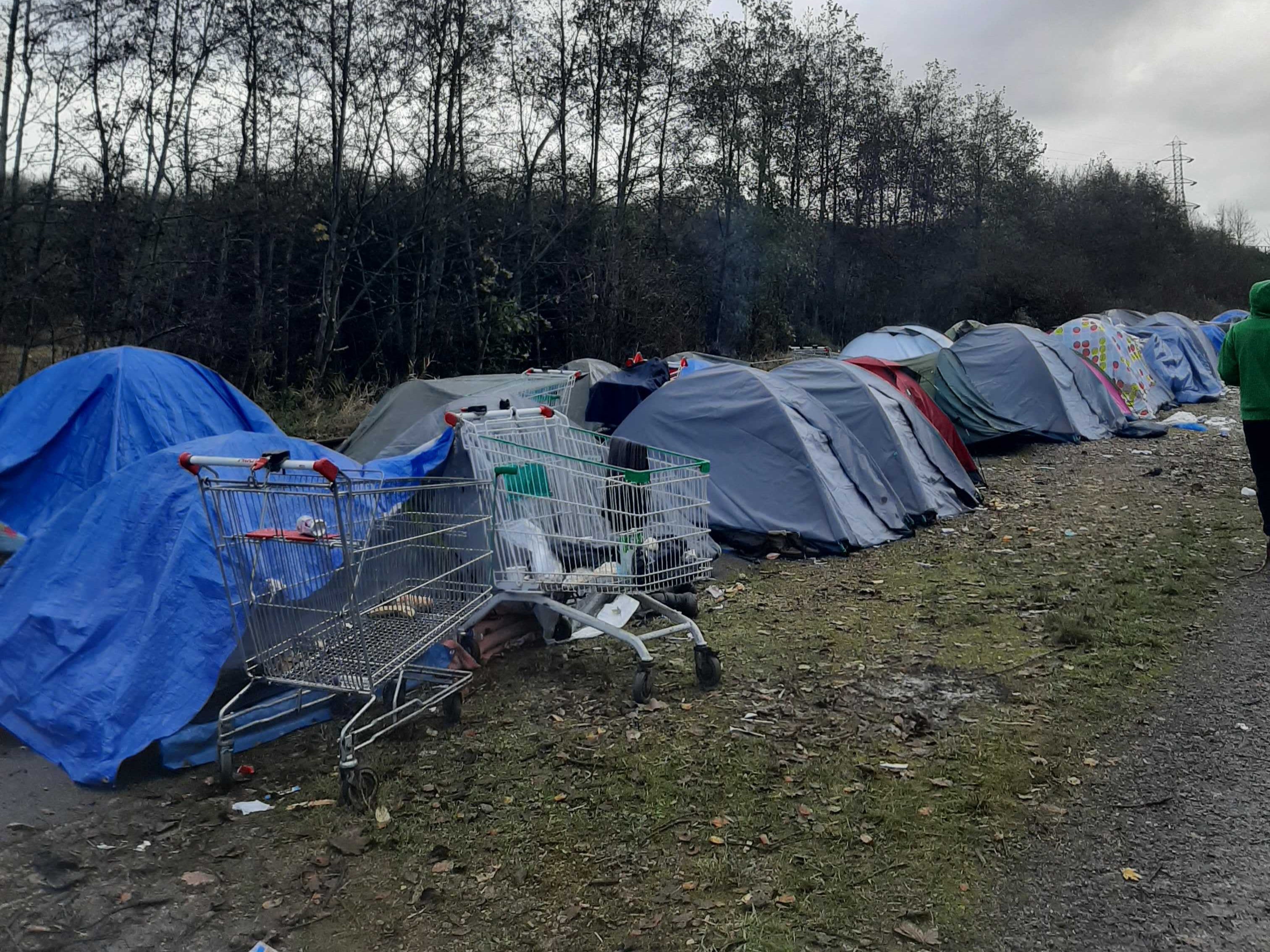 Tents are pitched next to a disused railway in Dunkirk