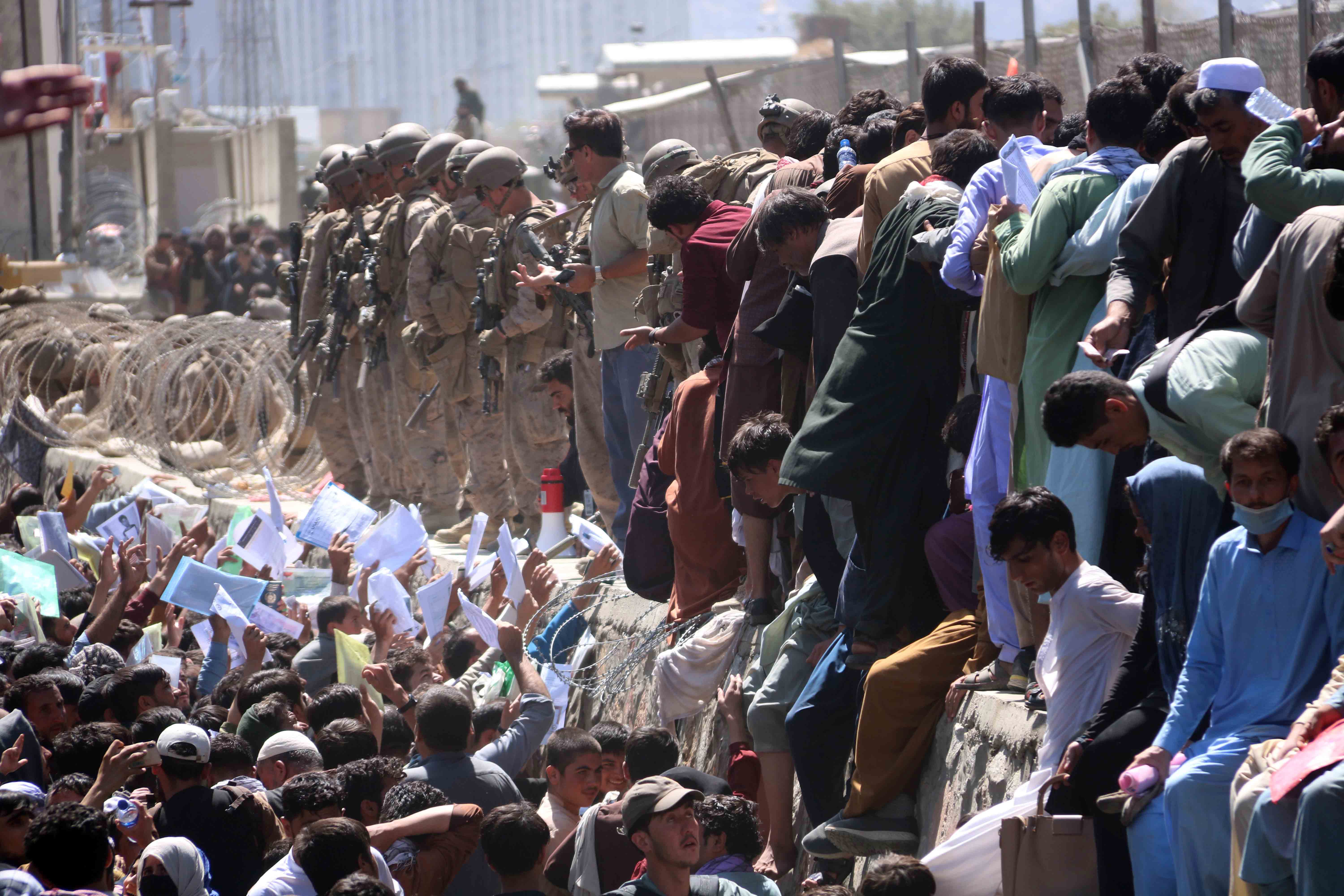 Afghans struggling to show their credentials to flee the country outside the Hamid Karzai international airport