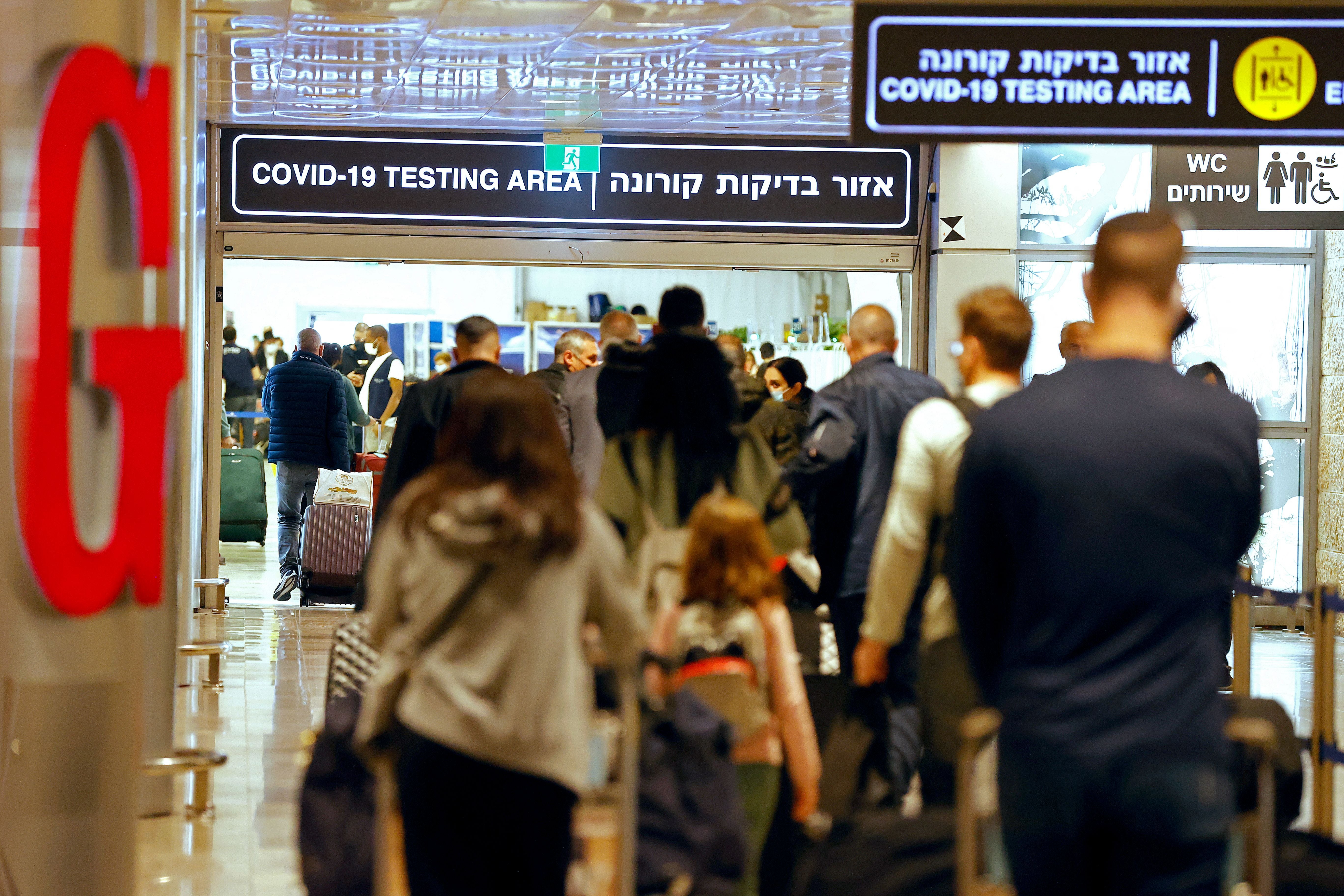 Passengers walk with their luggage upon their arrival at Israel’s Ben Gurion airport