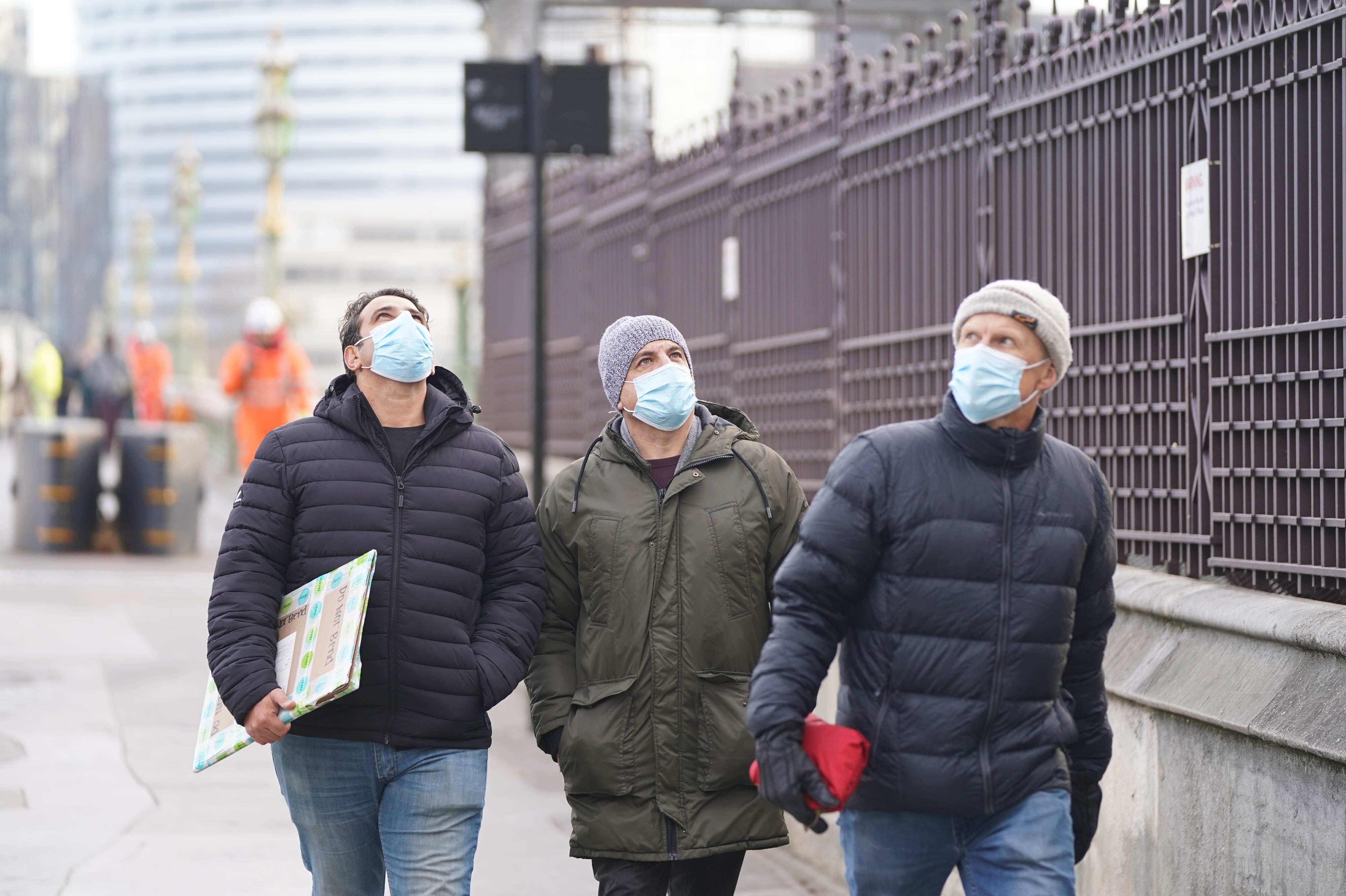 People wearing masks walking in Westminster, London (Stefan Rousseau/PA)