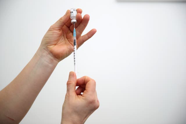 A vial of the Pfizer-BioNTech coronavirus vaccine prepared for injection. Health officials are expected on Monday to announce a further rollout of booster doses across the UK (PA)