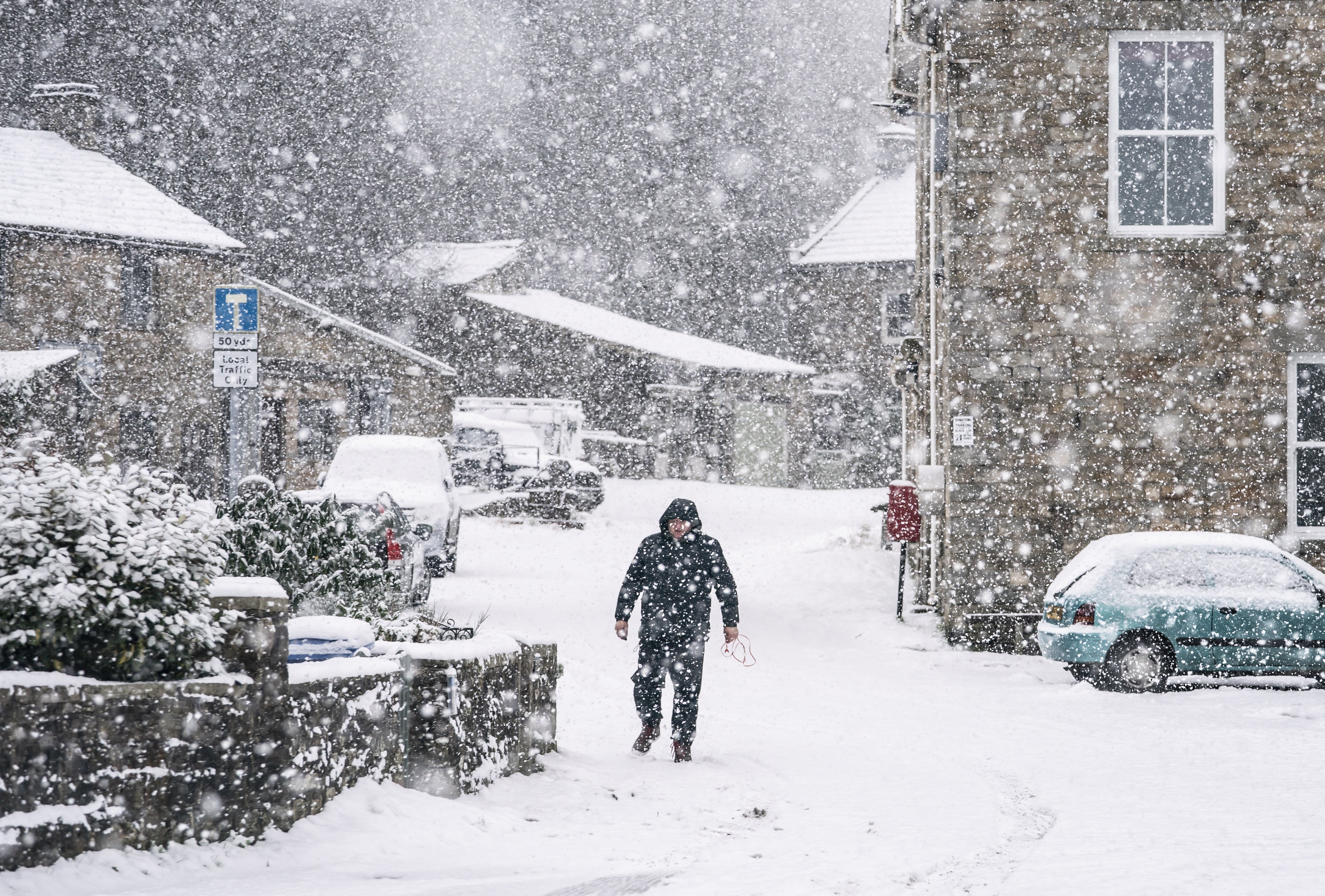 A man walks through the snow in Gunnerside, North Yorkshire (Danny Lawson/PA)