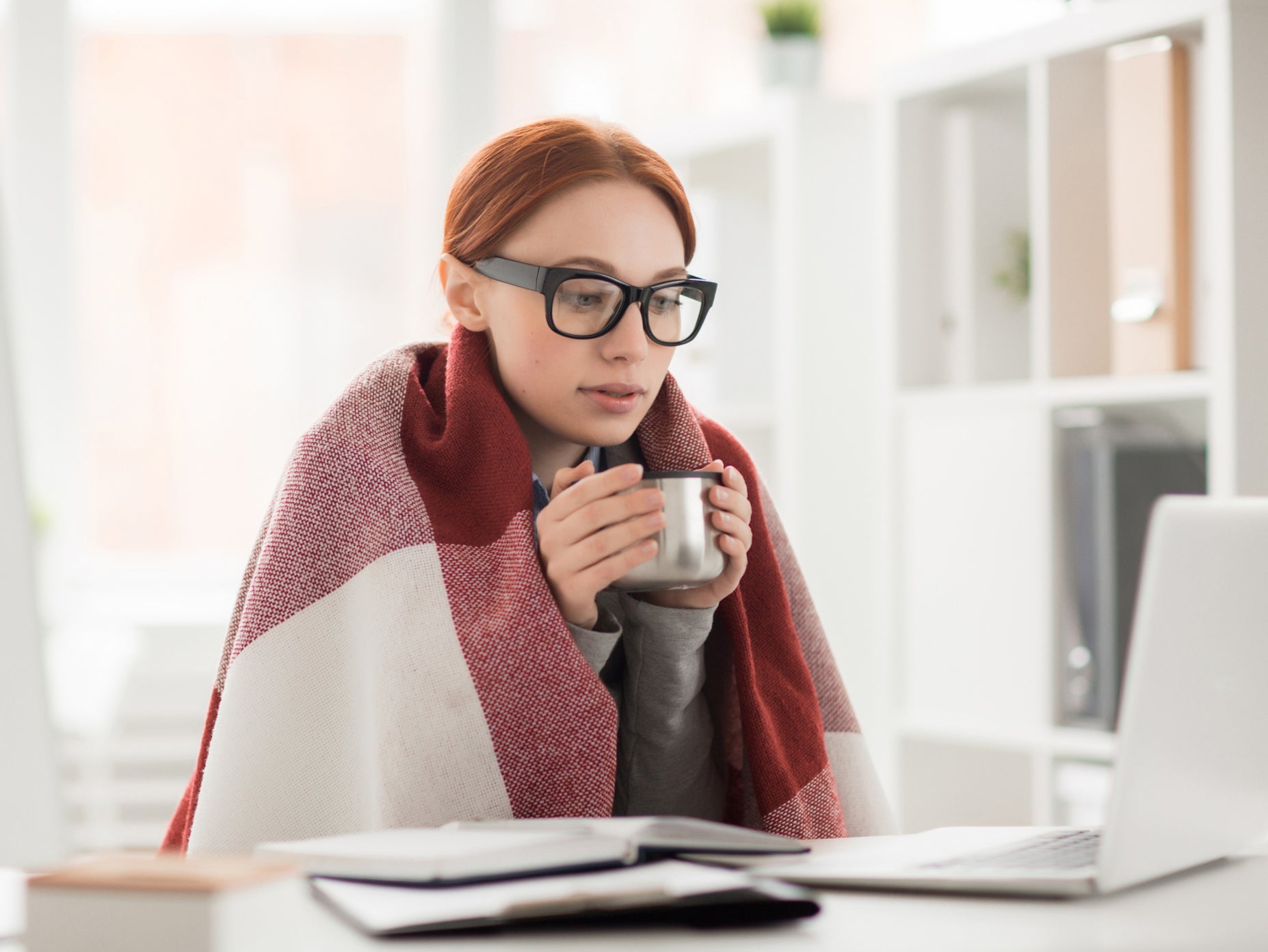 A person wears a blanket while at work