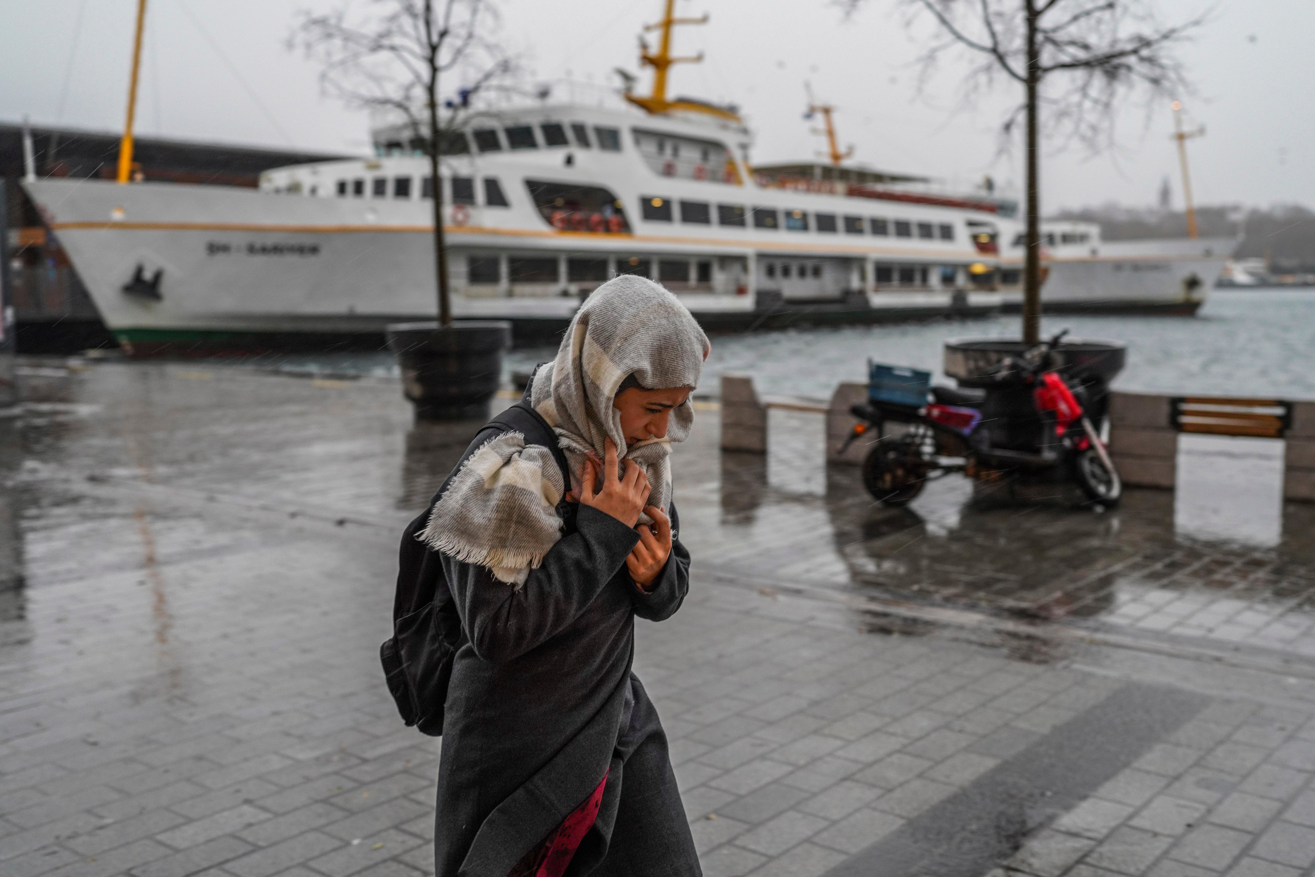 A woman walks under a heavy rain in Istanbul