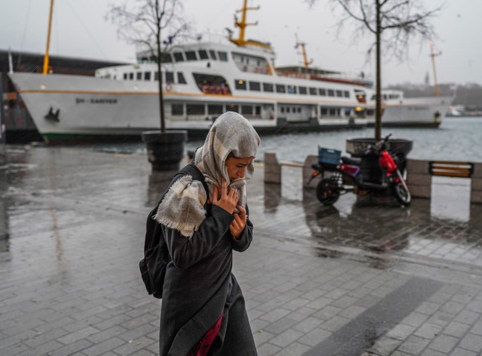 <p>A woman walks under a heavy rain in Istanbul</p>