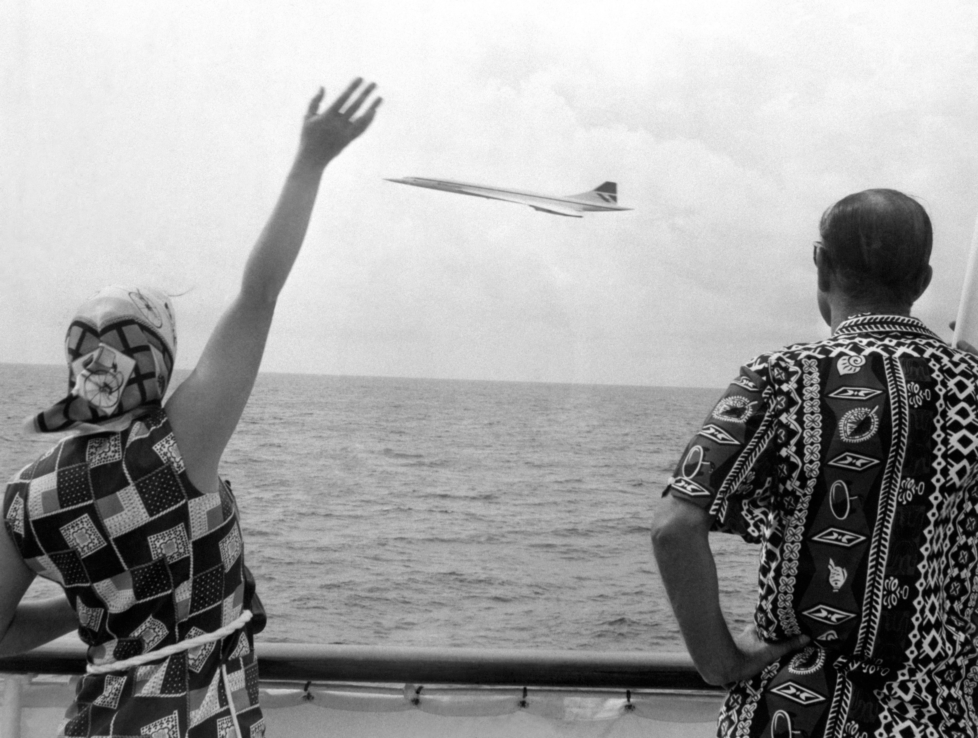 Queen Elizabeth II and Prince Philip wave as a Concorde plane flies by the Royal Yacht Britannia as the couple neared Barbados during their Silver Jubilee Tour in 1977