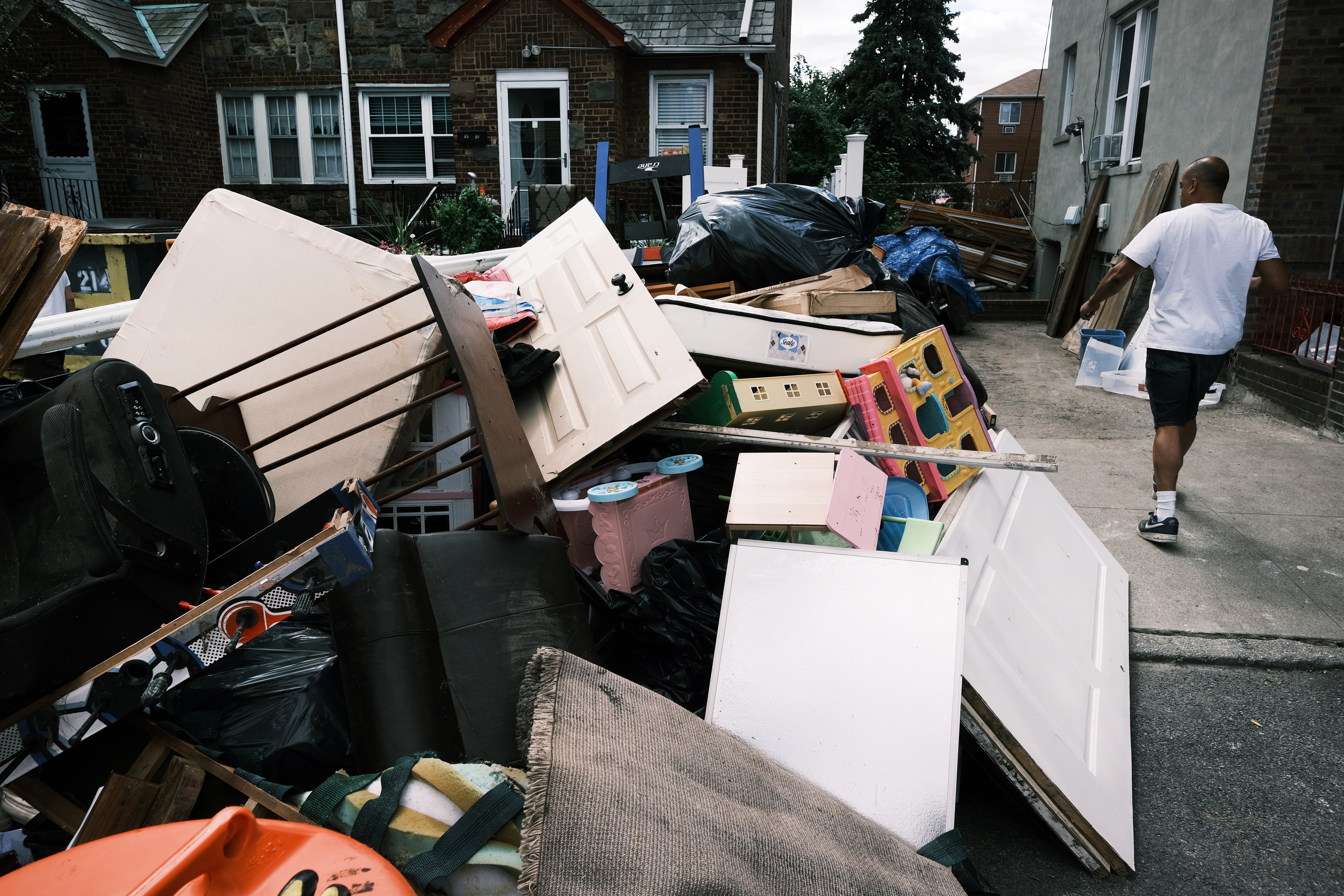 Residents sort through belongings from their flooded home in a Queens neighborhood that saw massive flooding and numerous deaths following a night of heavy wind and rain from the remnants of Hurricane Ida on September 3, 2021 in New York City