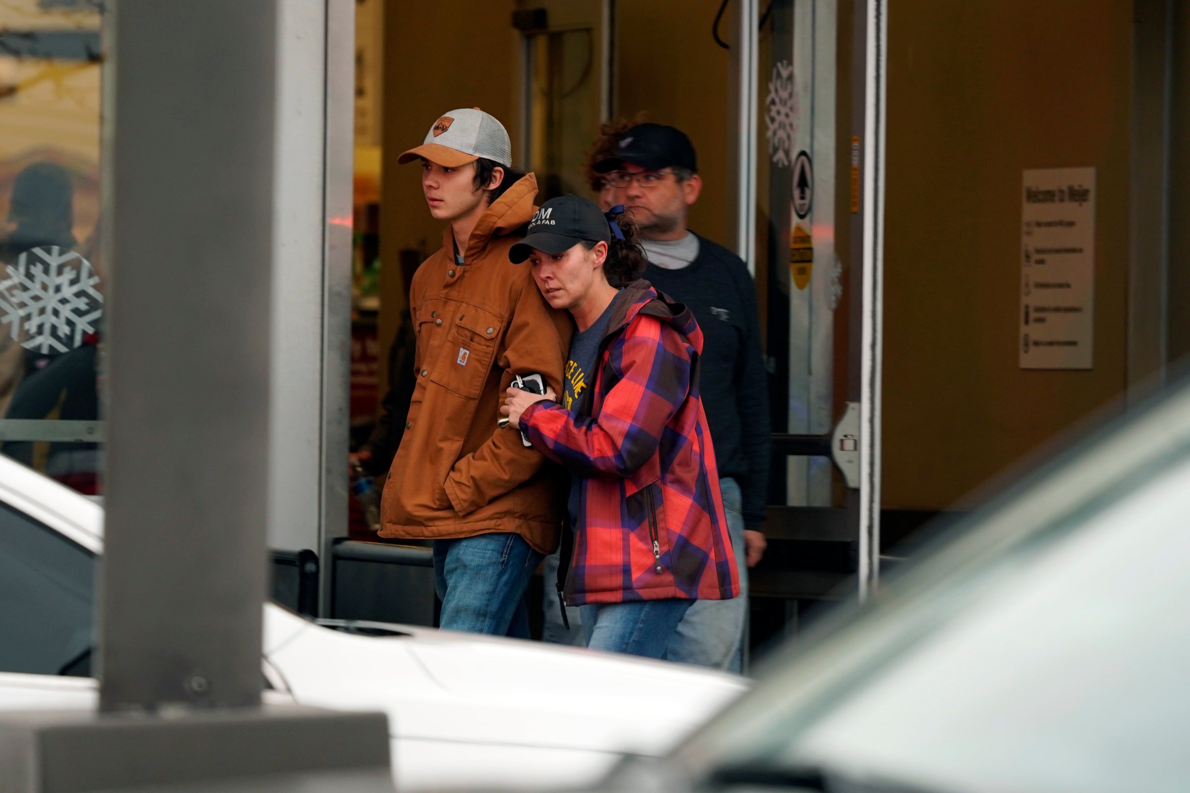 <p>A parent hugs a child as others come to pick up students from the Meijer store in Oxford, Mich., following an active shooter situation at Oxford High School in Oxford, Tuesday, Nov. 30, 2021</p>
