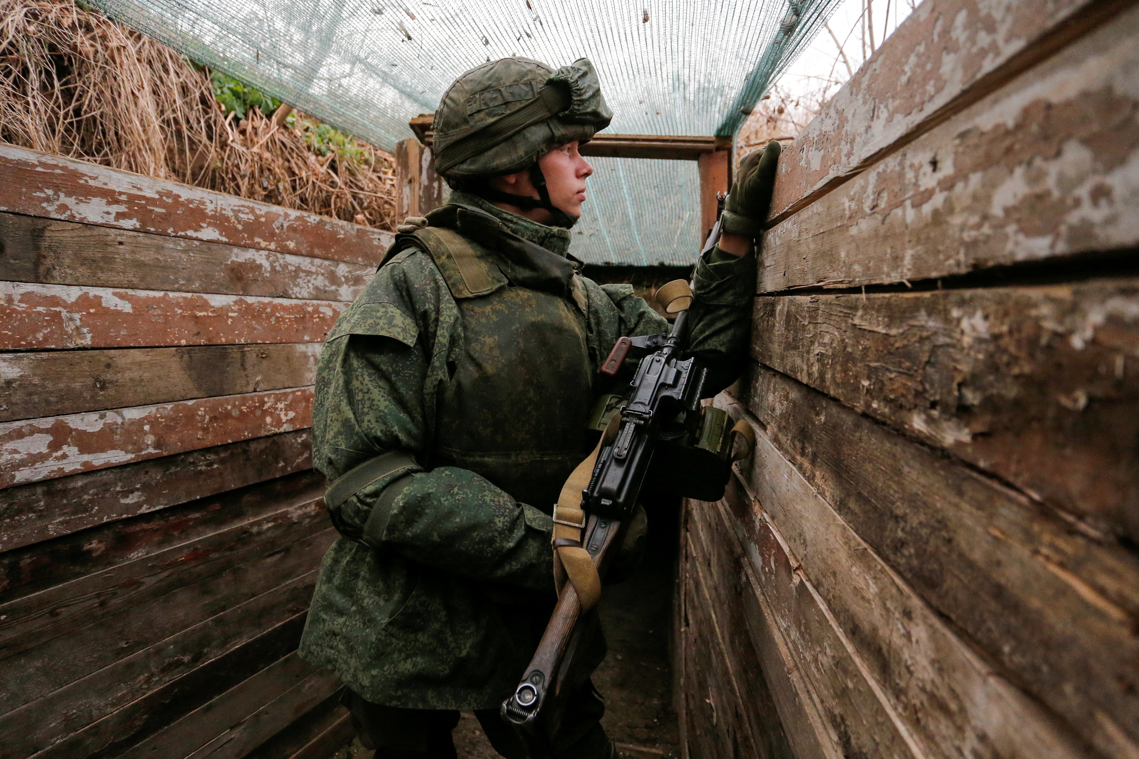 A militant of the self-proclaimed Donetsk People’s Republic (DNR) watches from a frontline position outside the rebel-controlled city