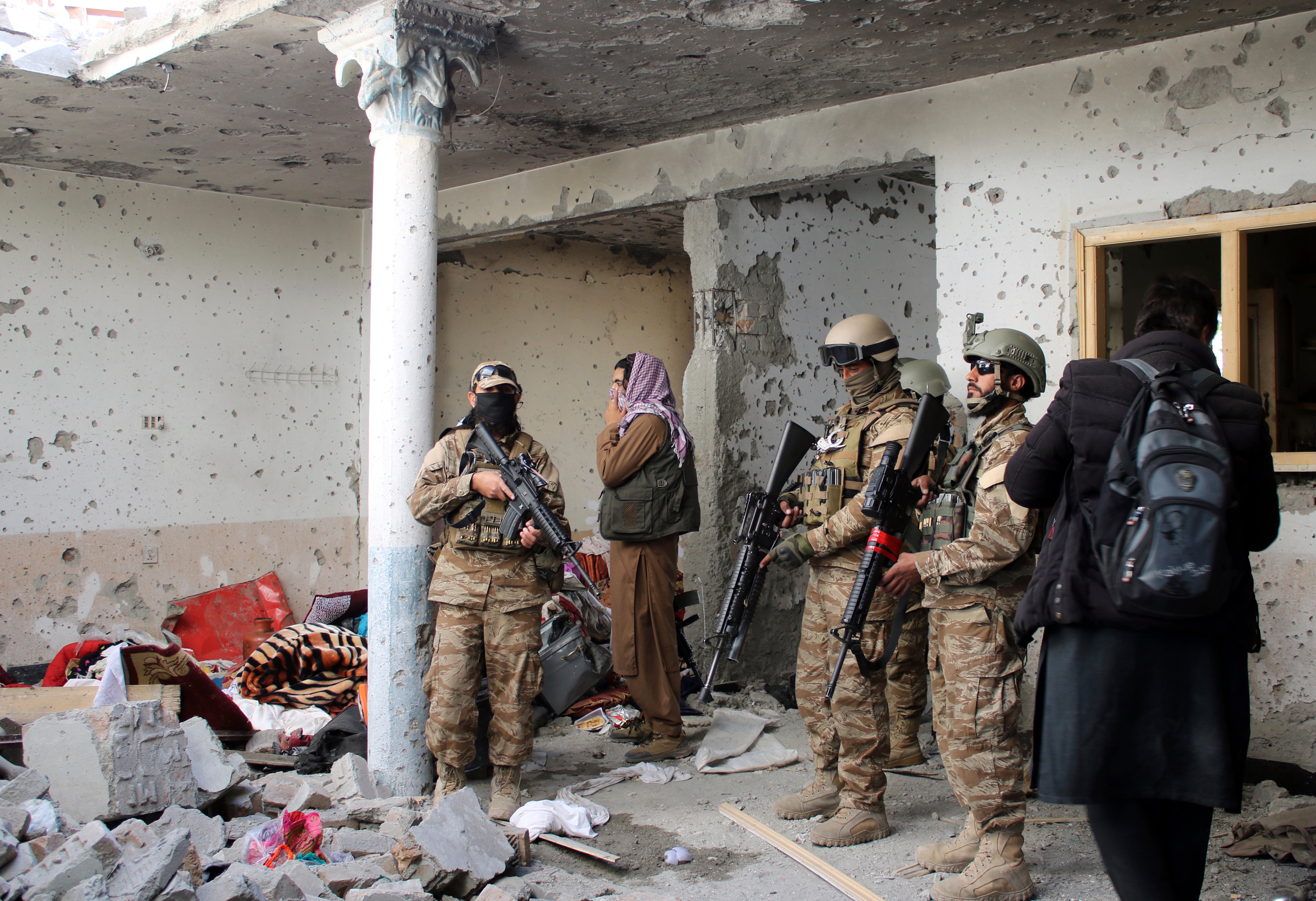 Taliban fighters inspect a house following a gun-battle with Islamic State fighters