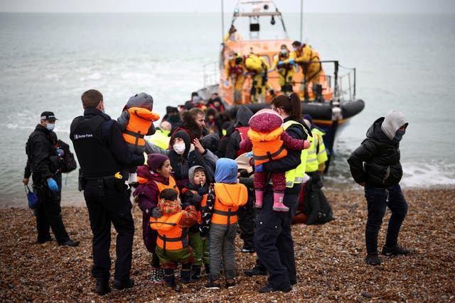 <p>Migrants are brought ashore in Dungeness, Kent, by RNLI Lifeboat staff, police officers and Border Force staff, after having crossed the English Channel on 24 November </p>