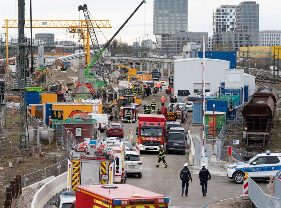 <p>Police and firefighters secure the scene at a bridge by the busy main train station in Munich</p>