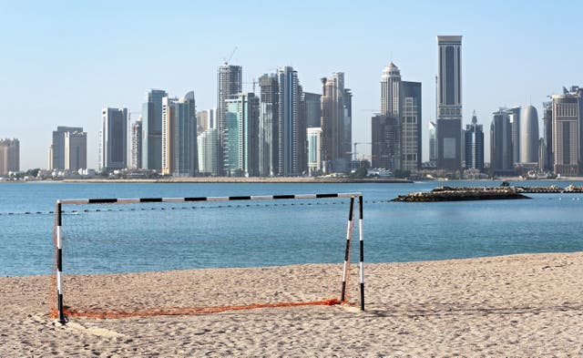 <p>A football goal at a beach in front of the skyline of Doha, Qatar</p>