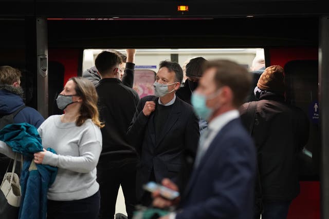 People wear masks while travelling on the London Underground (Stefan Rousseau/PA)