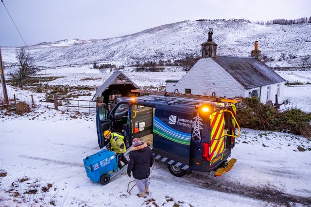 An SSEN engineer delivers a portable generator to a family at a remote cottage in Glenshee (Stuart Nicol/PA)