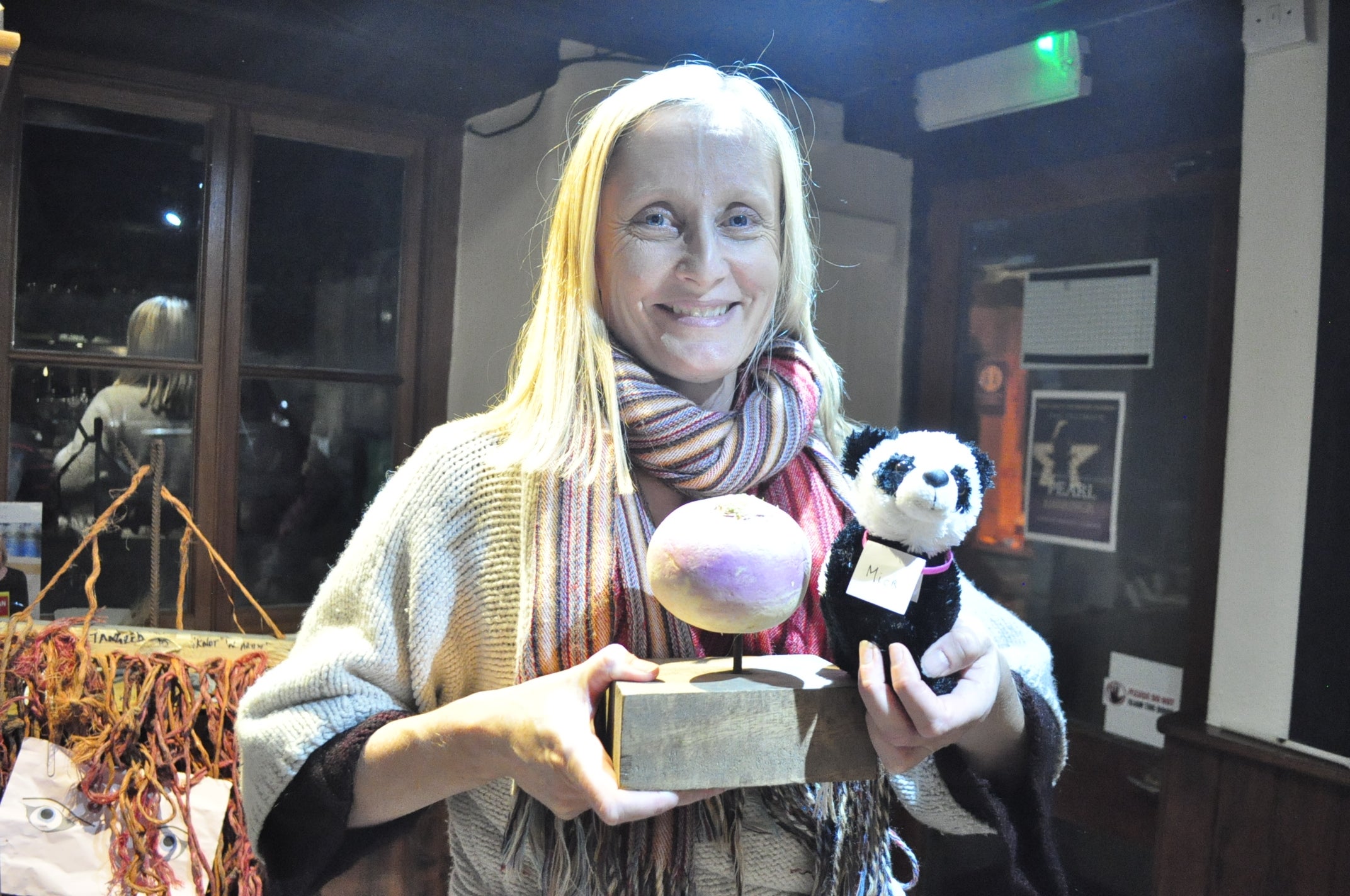 Emma Jones, the winner’s representative, with the Turnip Prize and the “Panda Mick” (A panda called Mick (Pandemic)) entry (Turnip Prize/PA).